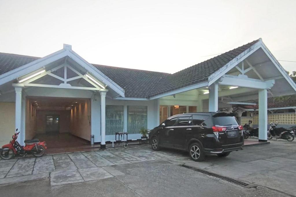 a black suv parked in front of a house at Urbanview Hotel Bahtera Tarakan by RedDoorz in Sibengkok