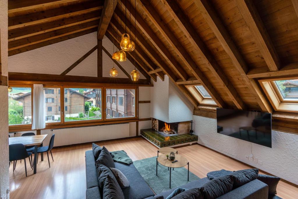 - un salon avec un canapé et une cheminée dans l'établissement Jungfrau-View Apartment, terrace & free parking, à Wilderswil