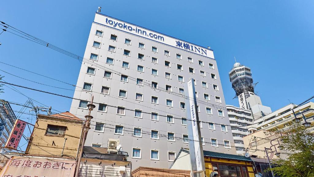 um edifício branco com uma placa em cima em Toyoko Inn Osaka Tsutenkaku Mae em Osaka