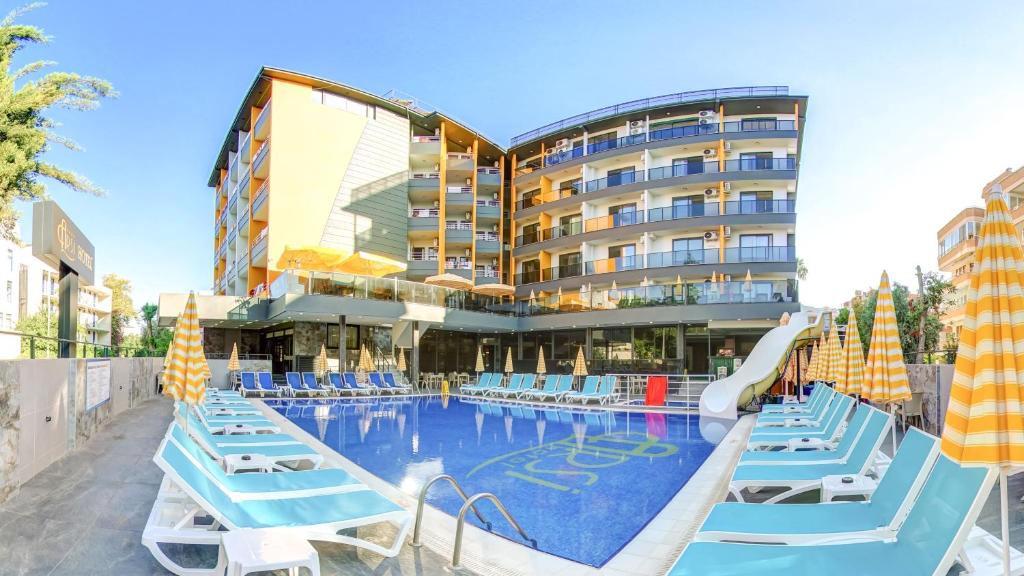a hotel with a pool with chairs and a slide at Arsi Hotel in Alanya