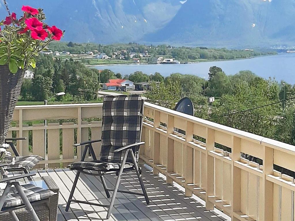 a chair on a balcony with a view of a lake at Holiday home SORTLAND II in Sortland
