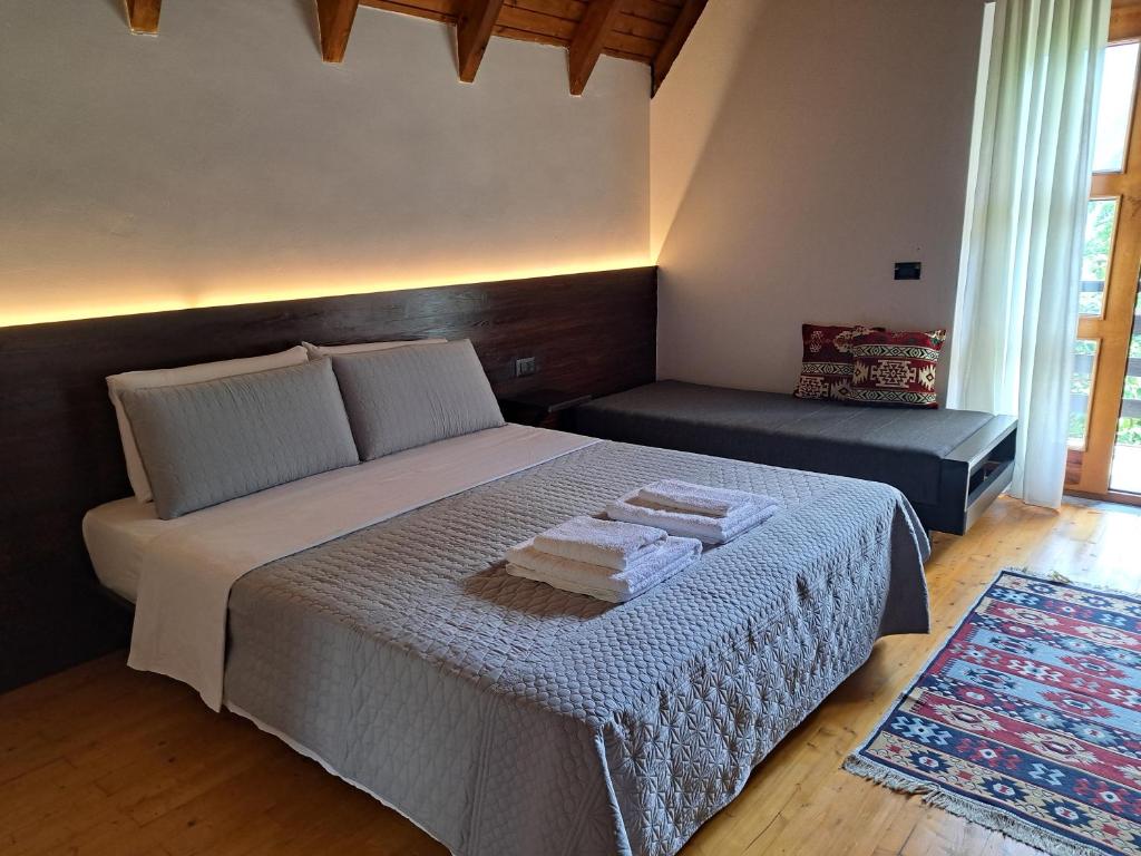 a bedroom with a bed with two towels on it at Villa Gjeçaj Guesthouse and Restaurant in Theth