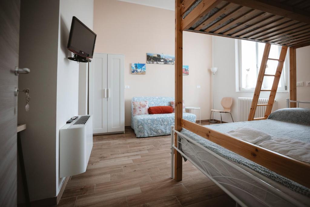 a bedroom with a bunk bed with a tv and a couch at Villa Valentina Versilia in Viareggio