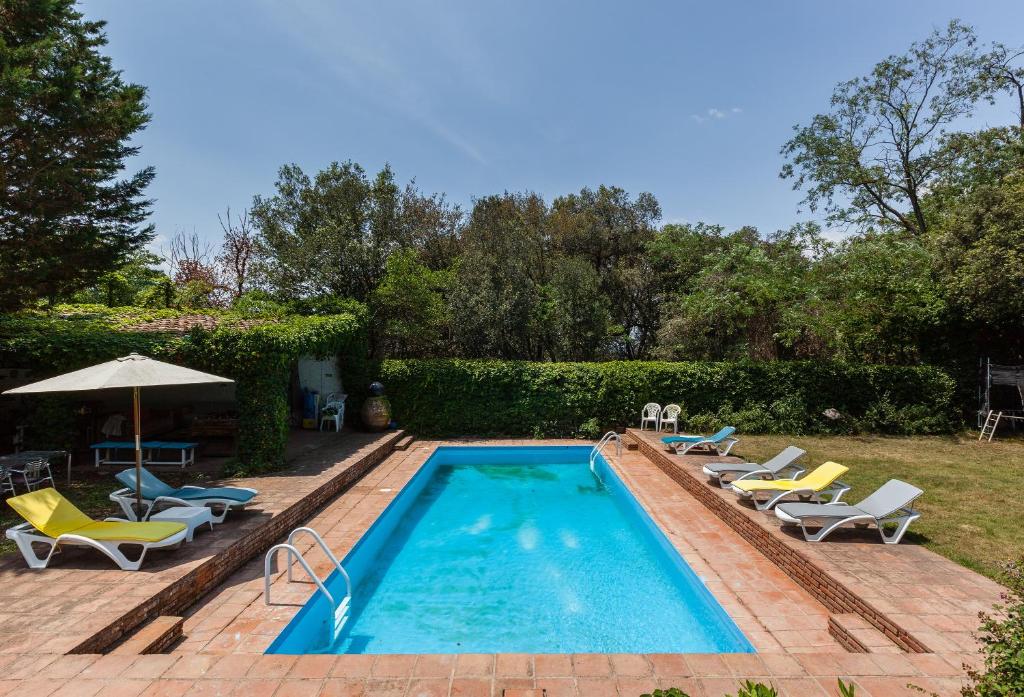 - une piscine avec des chaises et un parasol dans l'établissement Casanova, à Vallromanas