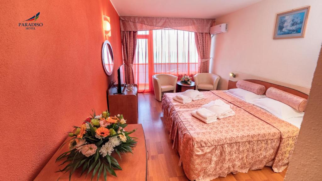 マンガリアにあるHotel Paradisoのホテルルーム ベッド2台、フロアの花