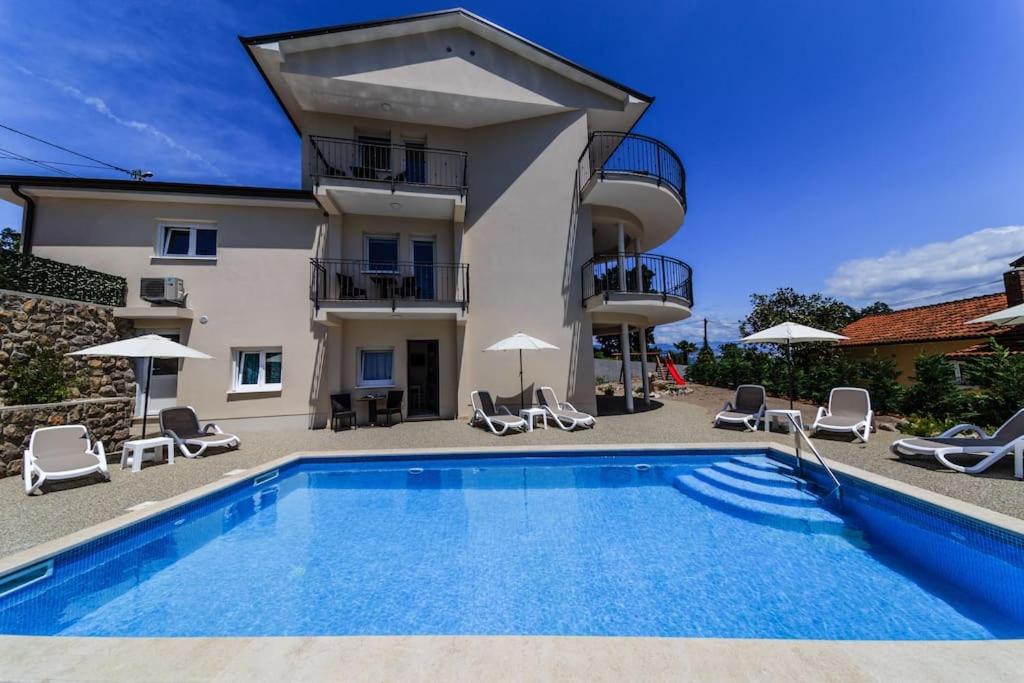 eine Villa mit einem Pool vor einem Gebäude in der Unterkunft Apt2 - Villa two Angels with swimming pool, Ika - Opatija in Ika