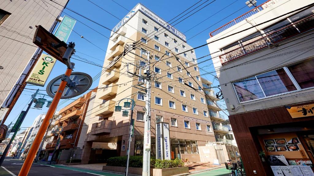 Toyoko Inn Tokyo Shinagawa Hatanodai eki Minami guchi في طوكيو: مبنى طويل على شارع في مدينة