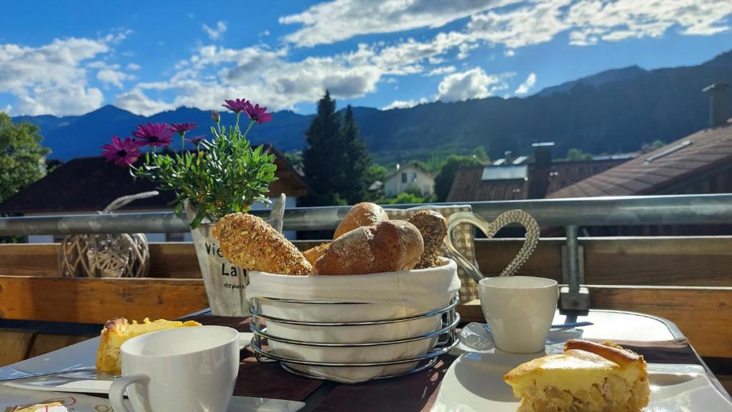 einen Tisch mit einem Korb Brot und Tassen Kaffee in der Unterkunft Ferienwohnung Alpenvogel in Sonthofen