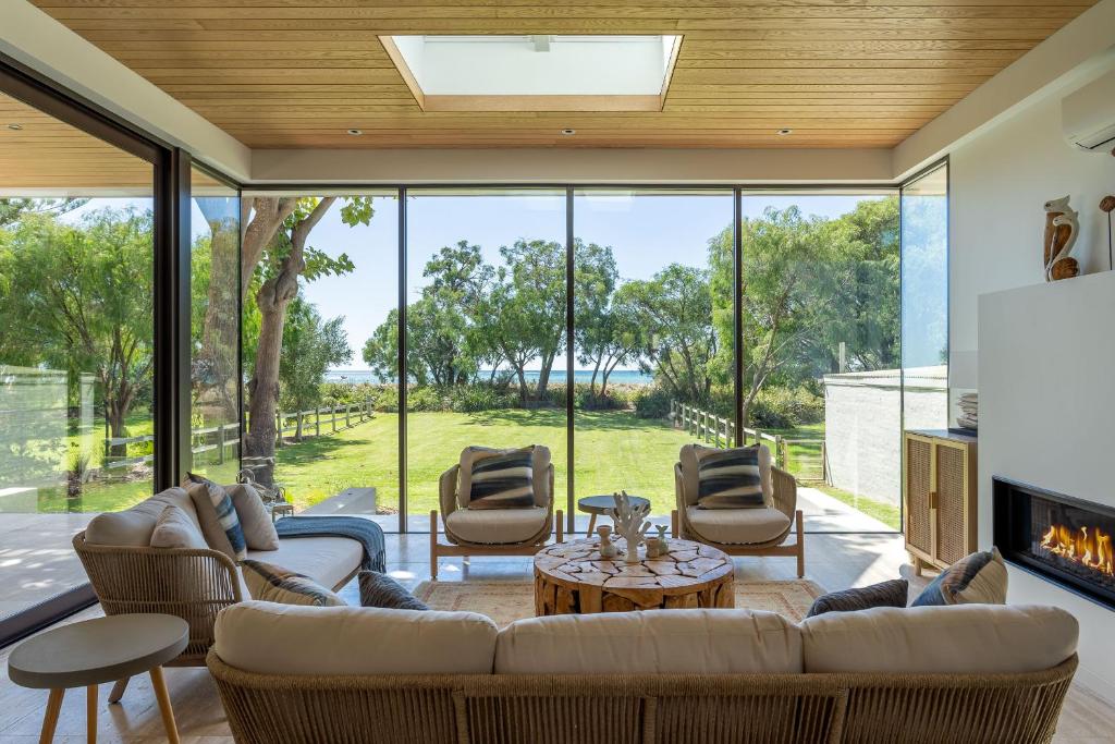 sala de estar con sofá, sillas y chimenea en Flametree I Private Properties, en Dunsborough