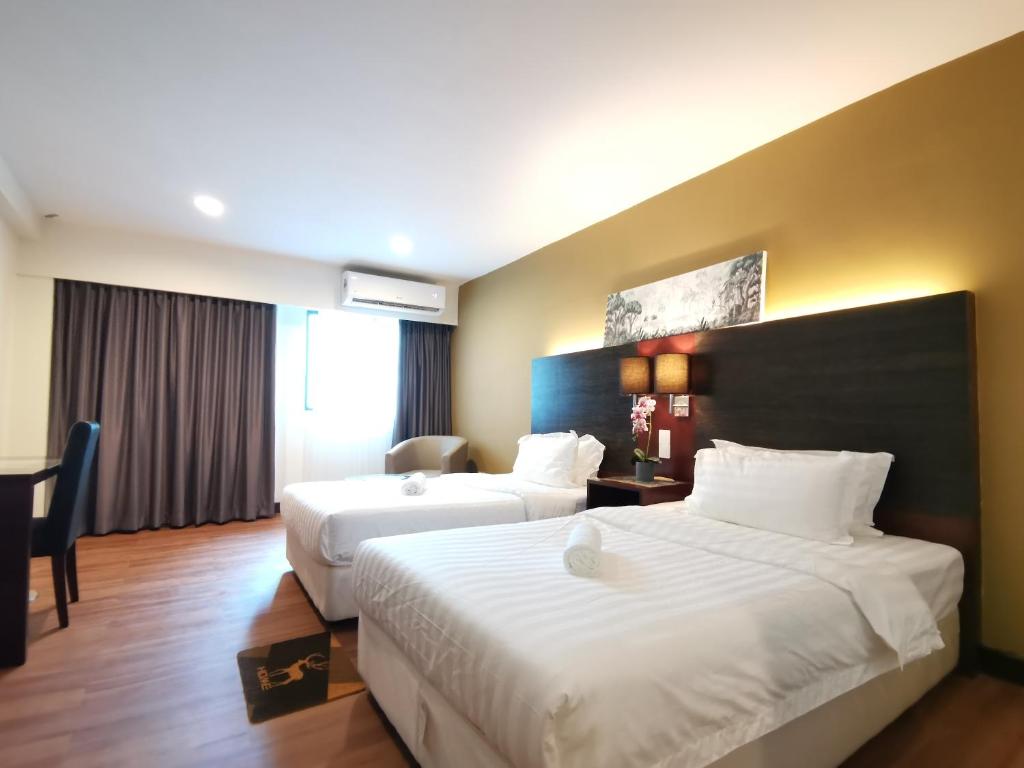Cette chambre comprend deux lits et un bureau. dans l'établissement Ming Greenage Suite 明绿时代套房 @Kota Kinabalu 亚庇市中心, à Kota Kinabalu