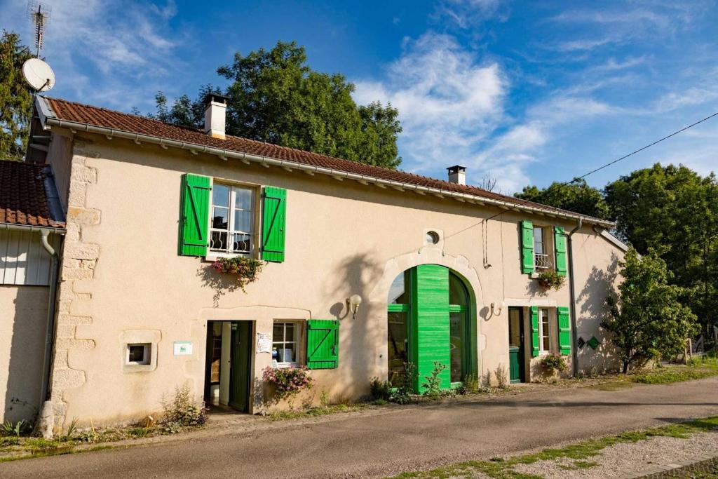 a white house with green shutters and a road at Dessine moi un mouton, chambre d'hôte à Soulosse in Soulosse-sous-Saint-Élophe