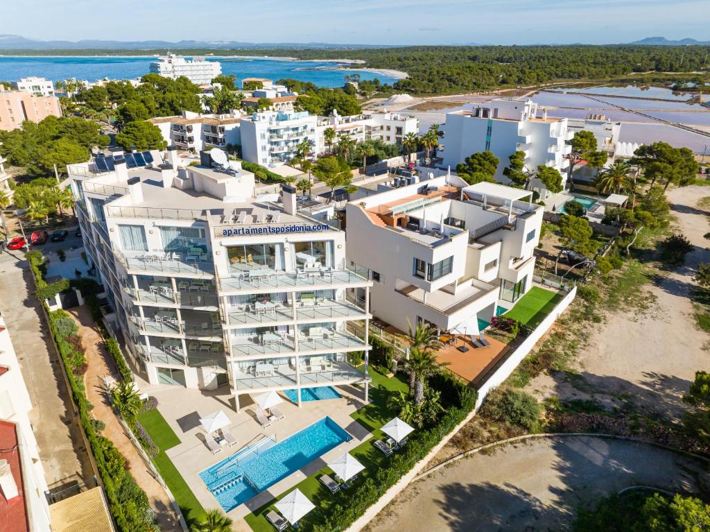 - une vue aérienne sur un immeuble d'appartements blanc doté d'une piscine dans l'établissement Apartaments Posidonia, à Colonia Sant Jordi