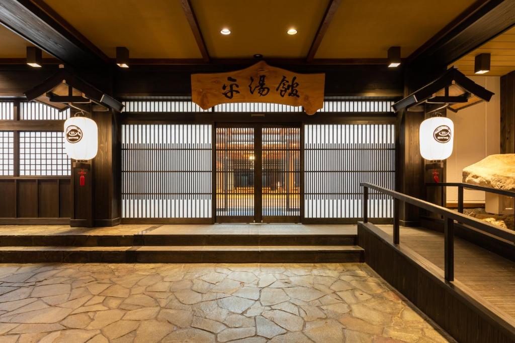een ingang naar een gebouw met een poort en een trap bij Hirayukan in Takayama