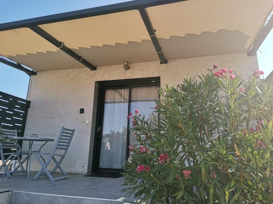 d'une terrasse avec une porte, une table et des chaises. dans l'établissement Les lauriers, à Uchaux