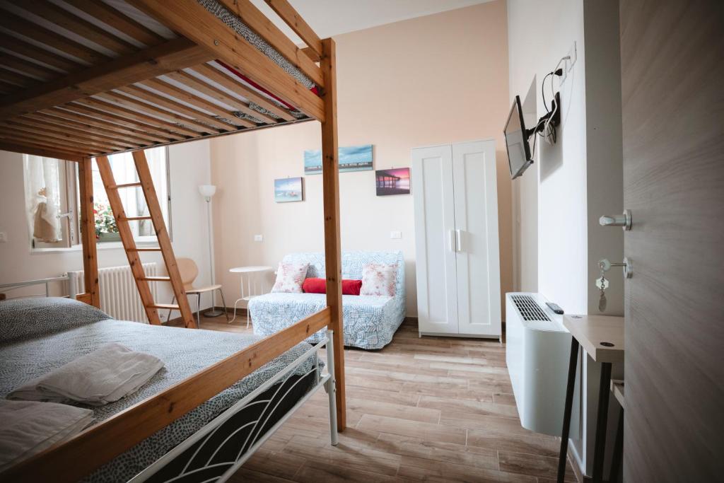a bedroom with a bunk bed and a chair at Villa Valentina Versilia in Viareggio