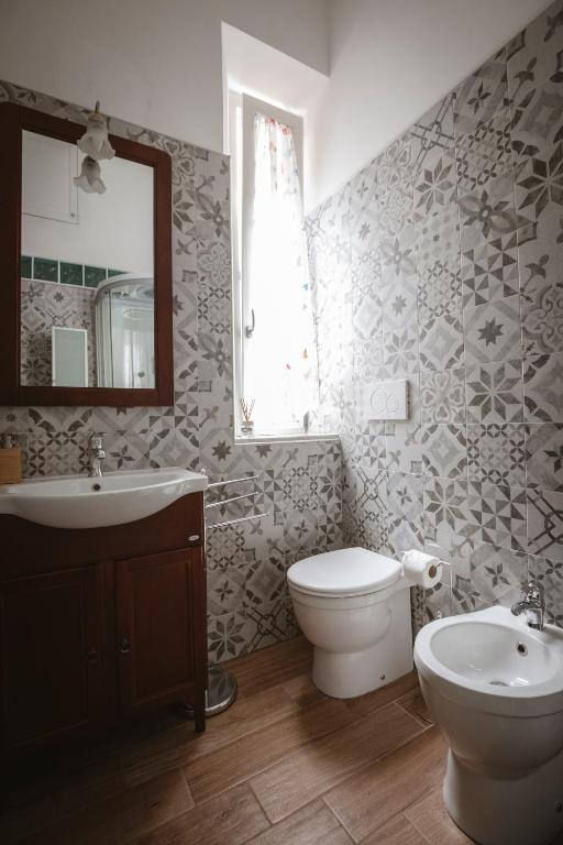 a bathroom with a toilet and a sink and a mirror at Villa Valentina Versilia in Viareggio