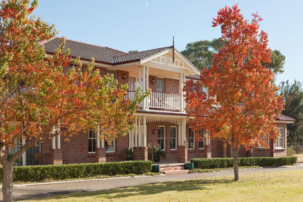 a brick house with trees in front of it at Plumes Boutique Bed & Breakfast in Tamworth