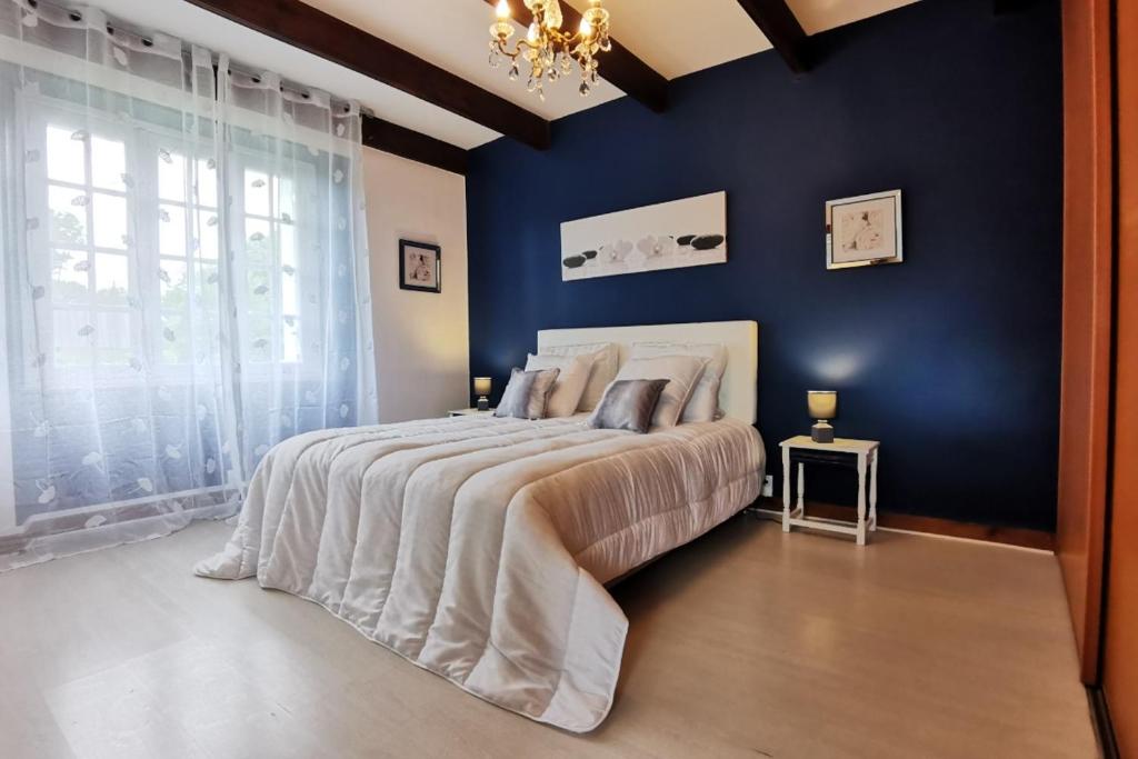 een slaapkamer met een groot bed met een blauwe muur bij Ti va zud kozh in La Feuillée