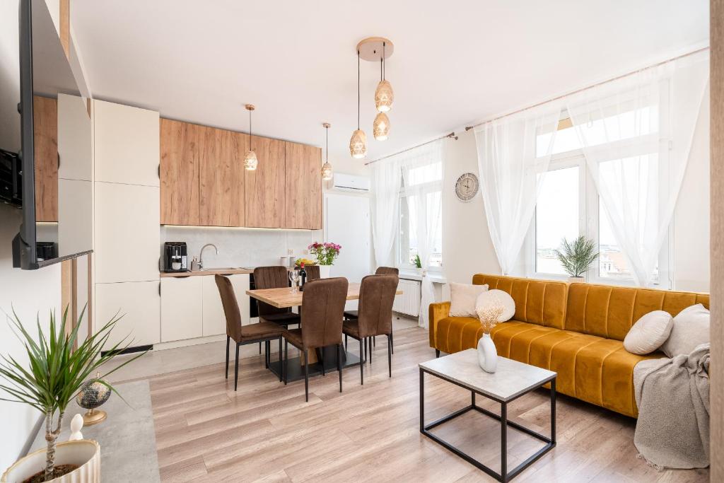 a living room with a yellow couch and a table at Basztowa Apartments in Kraków