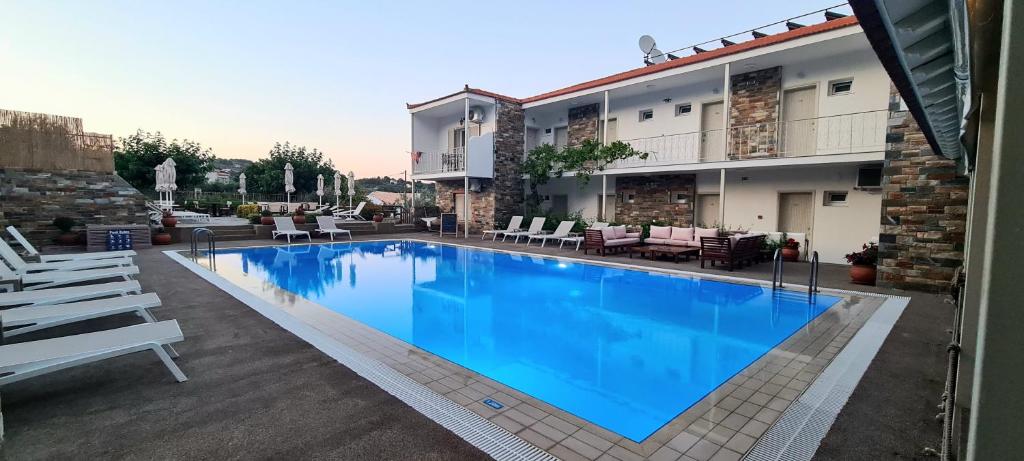 a large blue swimming pool in front of a building at Hotel Nereides in Patitiri