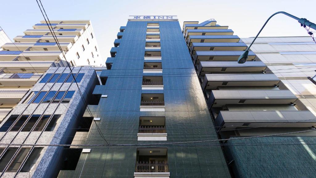 un alto edificio blu con finestre e luce di strada di Toyoko Inn Tokyo Nihombashi Zeimusho Mae a Tokyo