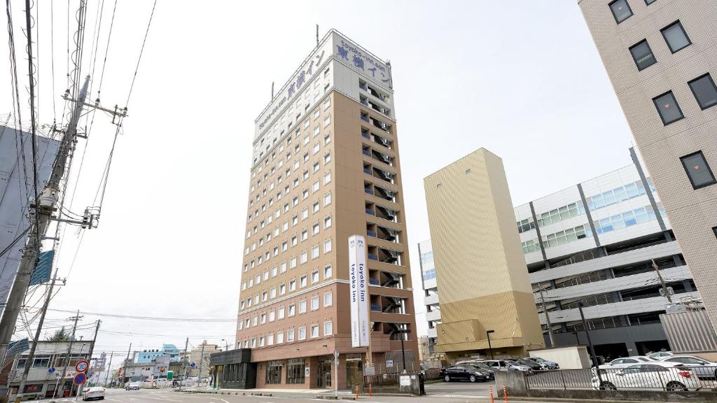 a tall building on a city street with buildings at Toyoko Inn Gumma Ota eki Minami guchi in Ota