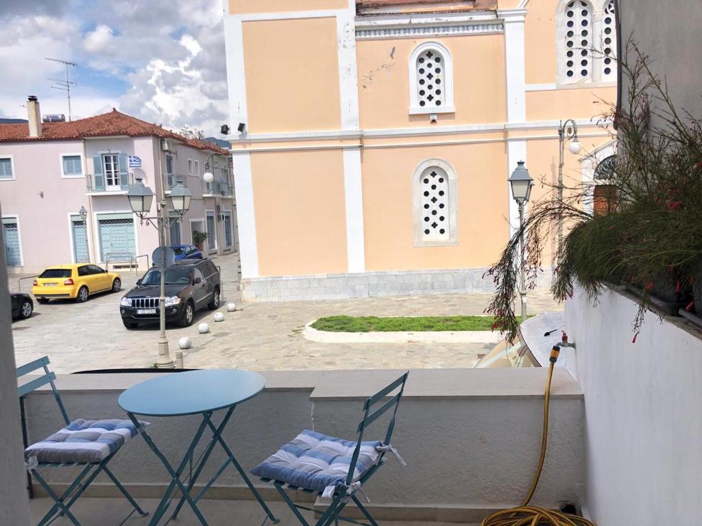 Un balcón con sillas y una mesa y un edificio. en Anna’s apartment, en Kalamata