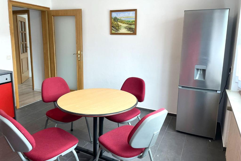 uma cozinha com uma mesa e cadeiras e um frigorífico em Apartment with balcony em Lennestadt