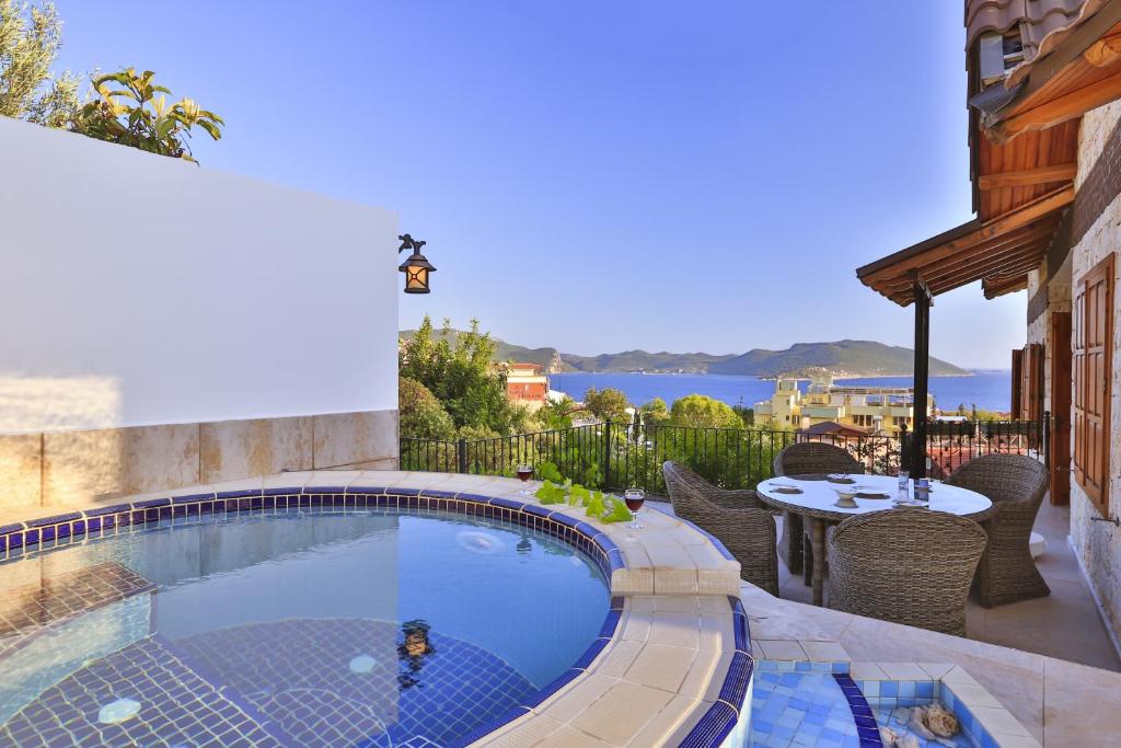 a swimming pool with chairs and a table on a patio at Çınarlar Apart KC Blok in Kaş