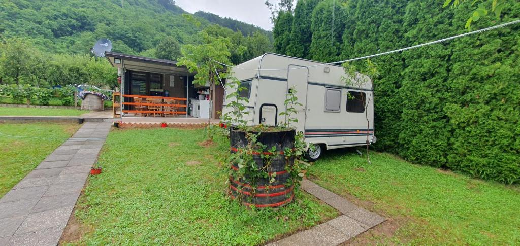 ein Wohnmobil in einem Hof neben einem Haus geparkt in der Unterkunft Kamp kućica trokrevetna in Crnča