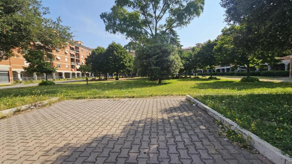 une passerelle en briques dans un parc avec des arbres et des bâtiments dans l'établissement La Dimora di Sofia, à Rome