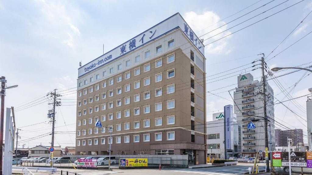 a large building with a sign on top of it at Toyoko Inn Ise Matsusaka Ekimae in Matsuzaka