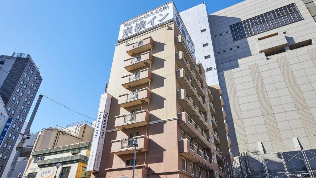 a tall building with a clock on the side of it at Toyoko Inn Chiba eki Higashi guchi in Chiba