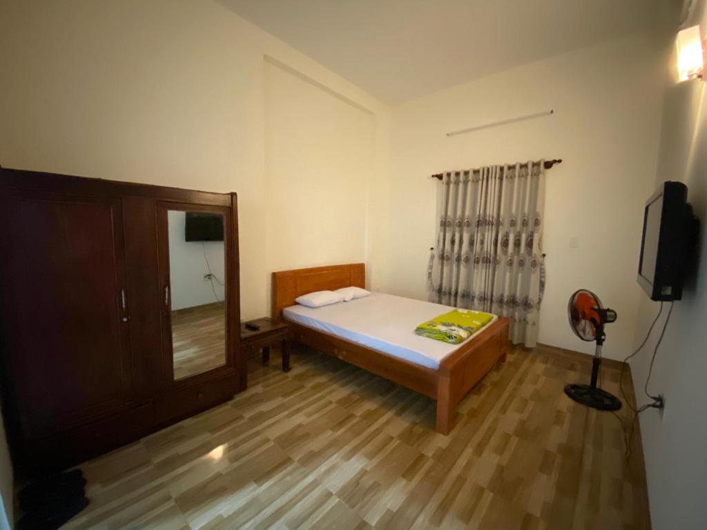 a small bedroom with a bed and a mirror at MOON Home in Vung Tau