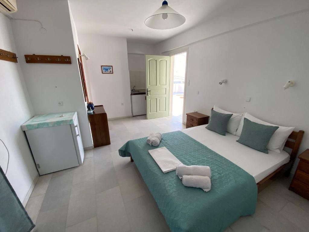 a bedroom with a large bed with towels on it at Asiminas in Naxos Chora