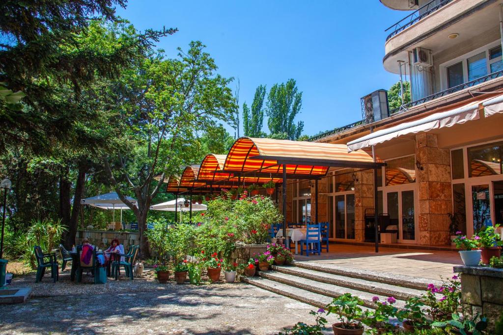 a patio with tables and umbrellas next to a building at ADIS Holiday Inn Hotel in Golden Sands