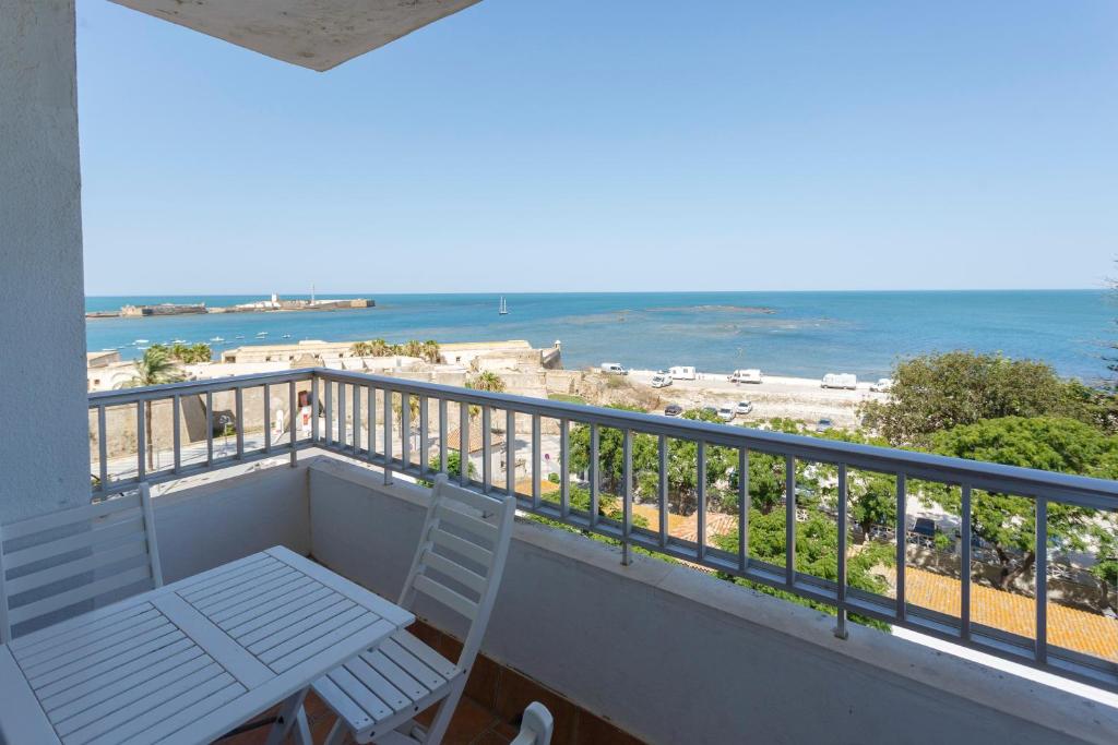 カディスにあるOCEANO Family Home free parking by Cadiz4Rentalsのビーチの景色を望むバルコニー(テーブル付)