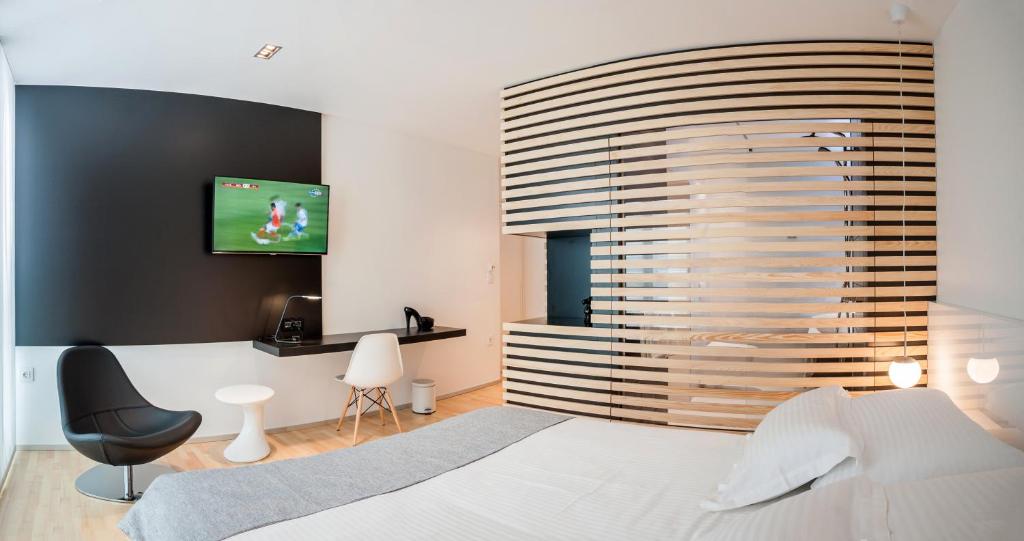 1 dormitorio con 1 cama y TV en la pared en Unique Rooms, en Zadar