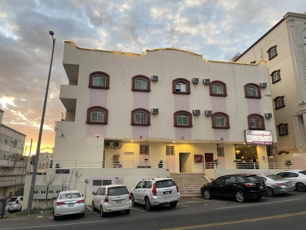 um edifício com carros estacionados em frente em نماء للشقق الفندقية em Abha