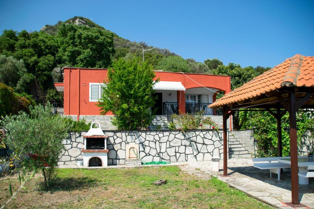 ein Haus mit einer Steinmauer und einem Pizzaofen in der Unterkunft Paradise residency in Nea Iraklitsa