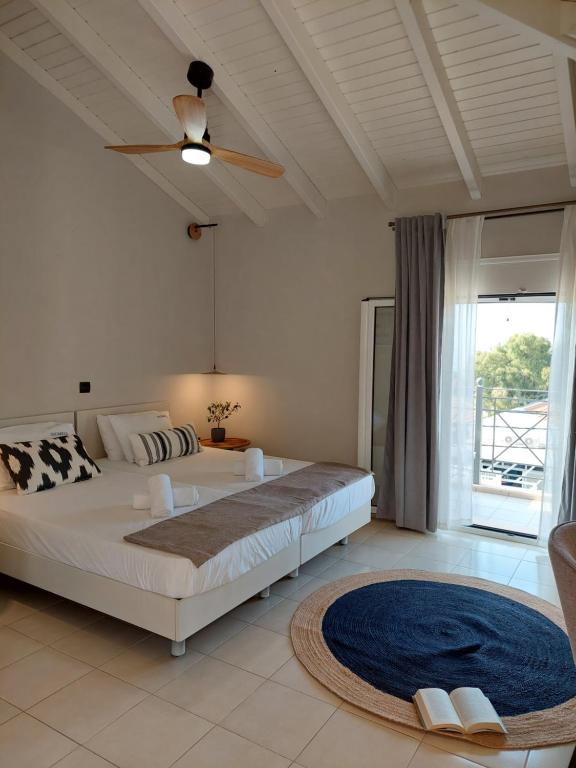 Nikkos Apartments في سكالا كيفالونياس: غرفة نوم بسرير كبير ومروحة سقف
