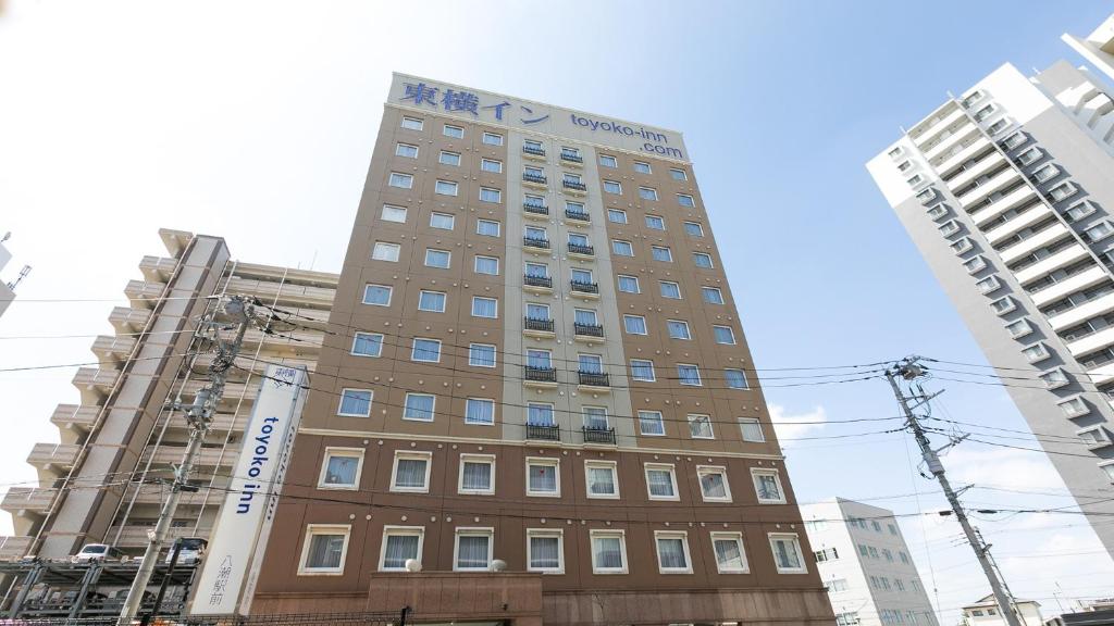 Toyoko Inn Yashio Ekimae في Yashio: مبنى طويل في وسط مبنيين