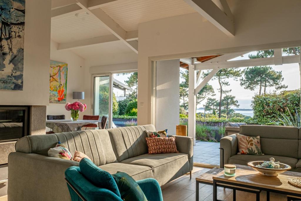 un salon avec un canapé et une table dans l'établissement Villa Marie - Pyla sur mer superbe villa 10 personnes vue Bassin, à La Teste-de-Buch