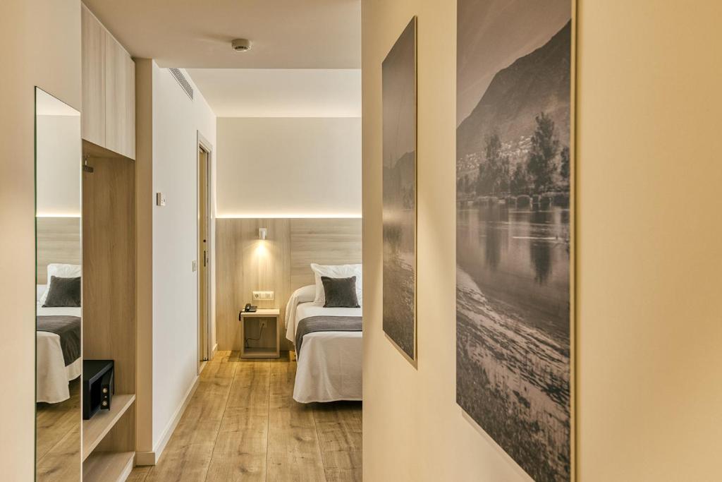 Hotel Emporium - Adults Only في كاستيلو دي إمبوريس: غرفة نوم بسريرين ولوحة على الحائط