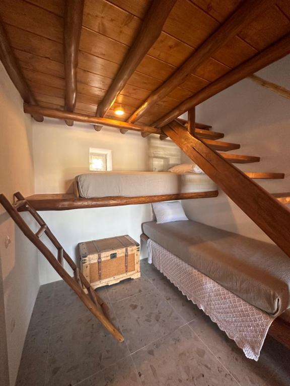 a room with two bunk beds and a wooden ceiling at Rizes Mykonos - Folklore Farmstead in Mýkonos City