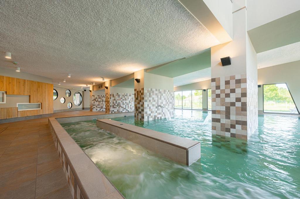 a swimming pool with water in the middle of a room at Glamping Schotsman in Kamperland