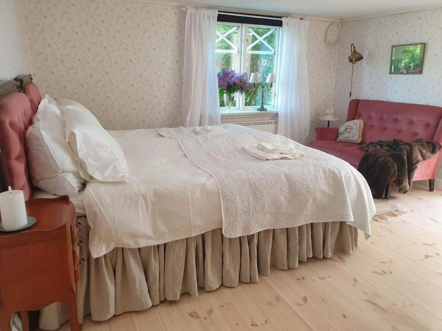 sypialnia z dużym łóżkiem i czerwoną kanapą w obiekcie Kyrkstallet 1 Historiskt med bästa läge Gränna w mieście Gränna