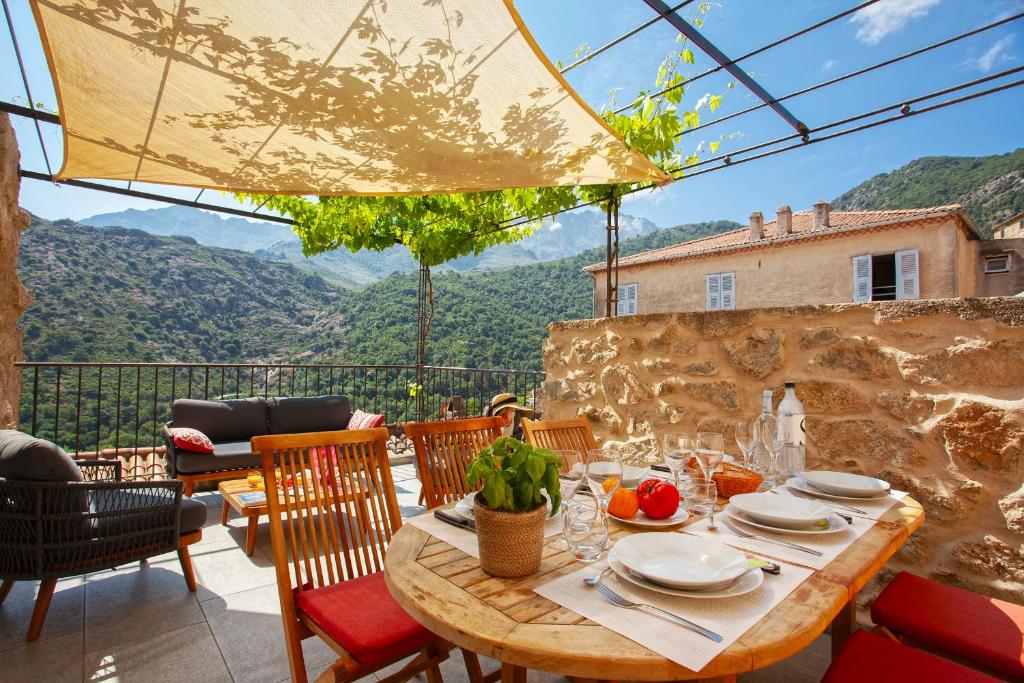 a table and chairs on a patio with a view at A StALLA MAISON DE VACANCES 6 PERSONNES in Muro