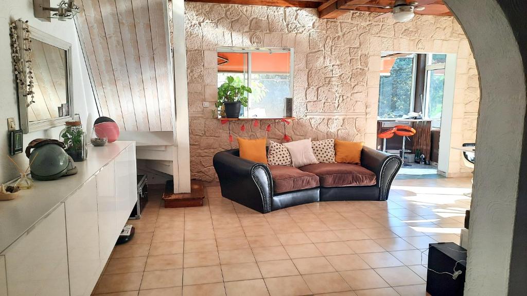 a living room with a leather couch and a table at Villa de 2 chambres avec piscine privee jardin clos et wifi a Merindol in Mérindol