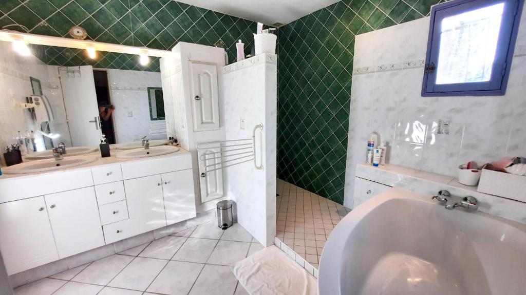 a bathroom with a tub and two sinks and a mirror at Villa de 2 chambres avec piscine privee jardin clos et wifi a Merindol in Mérindol